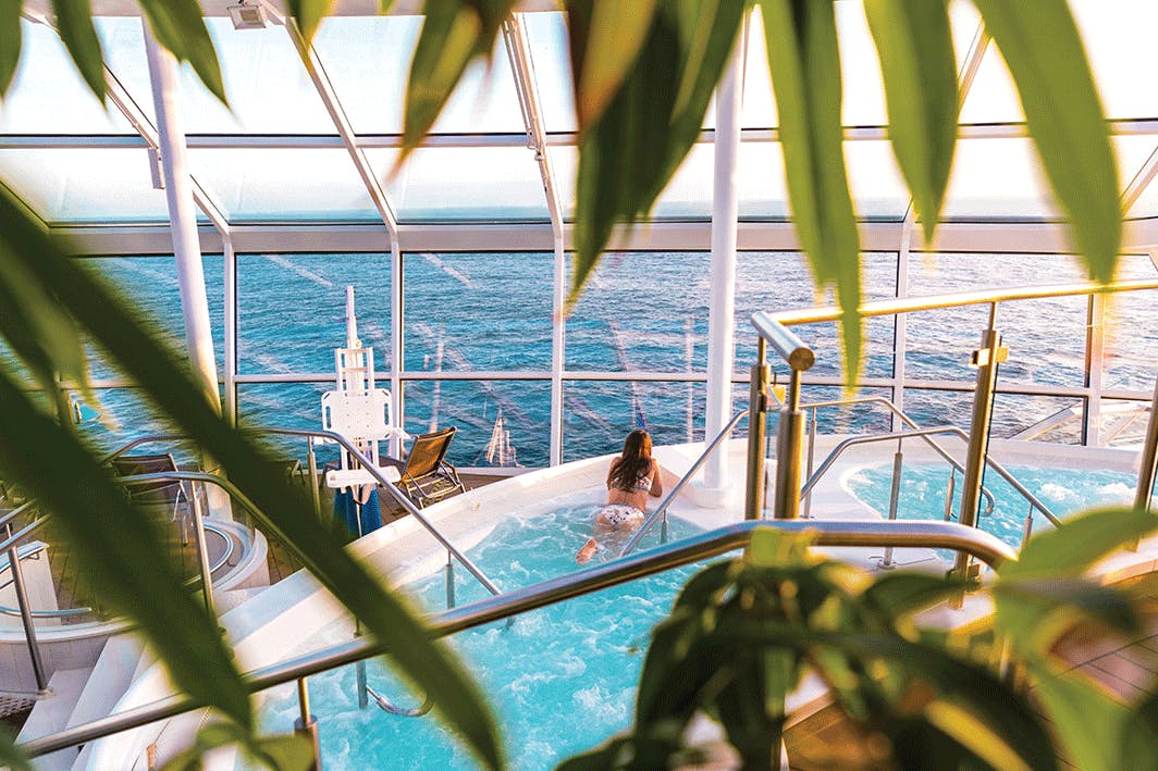 Woman in a pool on a cruise ship looking out to the ocean